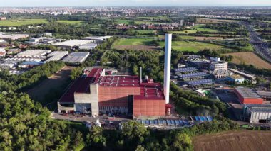 İtalya, Milan 'da atık yakma tesisi. Enerjiyi boşa harcamak. Duman yığını endüstriyel kurulum. Hava aracı videosu. Gün batımı altın saati. Hava aracı videosu.