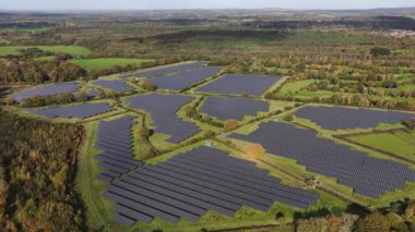 İngiliz kırsalındaki güneş panelleri. Güneşten yenilenebilir enerji. Çevre koruma ve enerji iyileştirmede yenilik. Hava aracı videosu.