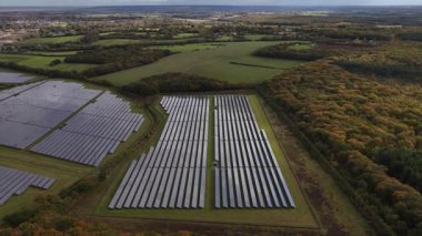 İngiltere 'nin kırsal kesimlerindeki güneş panelleri, Photovoltaic, güneş enerjisi üreten PV panelleri, İngiltere' nin kırsal kesimlerinde sürdürülebilir enerji geri kazanımı. Hava aracı videosu.