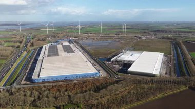 Aerial drone footage of a new, state of the art distribution center and warehouse complex at Logistics Park Moerdijk in the Netherlands. The facility complex is designed for high tech storage and Value Added Logistics VAL for modern international