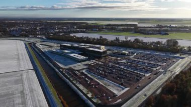 Aerial drone video of the modern Ommelander Hospital Groningen main facility in Scheemda, Netherlands, showcasing the energy-efficient architecture in a winter landscape.
