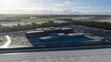 Aerial drone video of the modern Ommelander Hospital Groningen main facility in Scheemda, Netherlands, showcasing the energy-efficient architecture in a winter landscape.