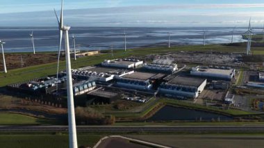 Hollanda 'nın Eemshaven kentindeki bir yapay zeka veri merkezinin dış yüzeyini gösteren hava videosu, önemli bir yatırım ve bilgisayar gücü genişlemesi alanı. Bina dijital altyapının geleceğini temsil ediyor..