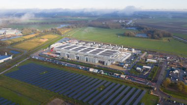 Geniş ölçekli veri merkezinin dikey hava aracı görüntüsü yenilenebilir enerji suretleri ve güneş panelleri gösteriyor. Yapay zeka altyapısı ve yapay enerji tüketimi ile yapay zeka devrimi.