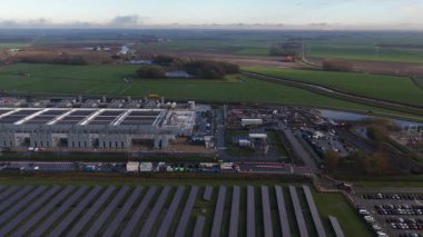 Geniş ölçekli veri merkezinin dikey hava aracı görüntüsü yenilenebilir enerji suretleri ve güneş panelleri gösteriyor. Yapay zeka altyapısı ve yapay enerji tüketimi ile yapay zeka devrimi.