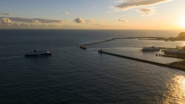Dover, Kent County, İngiltere, 25 Ekim 2025: Dover, İngiltere 'den gelen bir feribotun, Fransa' dan gelen araba ve kamyonları, altın saat boyunca dramatik bir günbatımında yakaladığı hava aracı videosu.