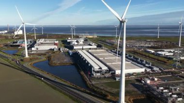 Hollanda 'nın Eemshaven kentindeki bir yapay zeka veri merkezinin dış yüzeyini gösteren hava videosu, önemli bir yatırım ve bilgisayar gücü genişlemesi alanı. Bina dijital altyapının geleceğini temsil ediyor..