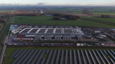 Dıştaki büyük bir veri merkezinin hava aracı videosu, veri depolama, işleme ve küresel dijital hizmetlerin dağıtımı için gereken muazzam teknolojik altyapıyı temsil ediyor..