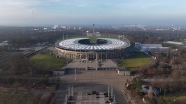 Berlin, Westend 'deki Olimpiyat Stadyumu' nun ikonik mimarisi, tarihi önemi ve Almanya 'nın başkentinde önemli bir spor ve kültür simgesi olarak oynadığı hava aracı videosu.