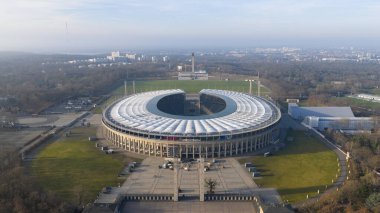 Berlin, Westend 'deki Olimpiyat Stadyumu' nun ikonik mimarisi, tarihi önemi ve Almanya 'nın başkentinde önemli bir spor ve kültür simgesi olarak oynadığı hava aracı videosu.