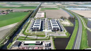 Büyük ölçekli bir veri merkezinin, büyük veri işleme, devasa bilgisayar gücü, bulut hizmetleri ve veri depolama için endüstriyel altyapısını gösteren, yaz günündeki hava aracı videosu..