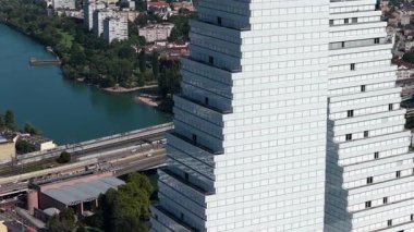 Basel, Basel Kantonu, İsviçre, 12 Ağustos 2025: Basel, İsviçre 'de Roche Kuleleri silueti, modern mimari, şirket genel merkezi ve şehrin ekonomik merkezinin yer aldığı kentsel altyapıyı gösteren hava aracı videosu.