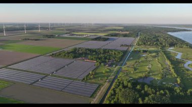 Eski bir golf sahasının hava aracı görüntüsü güneş çiftliğine dönüşerek güneş panellerinin sıralarını yakalıyor ve yaz mevsiminde yenilenebilir enerji üretiyor..