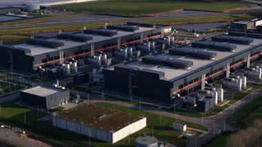 Hollanda, Middenmeer 'deki büyük ölçekli bir veri merkezinin hava aracı videosu, gelişmiş bilgisayar, depolama sistemleri ve bulut hizmetlerine güç veren yapay zeka altyapısı ve yüksek performanslı veri işleme sergiliyor..