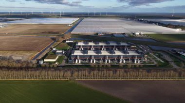 Hollanda, Middenmeer 'deki büyük ölçekli bir veri merkezinin hava aracı videosu, gelişmiş bilgisayar, depolama sistemleri ve bulut hizmetlerine güç veren yapay zeka altyapısı ve yüksek performanslı veri işleme sergiliyor..