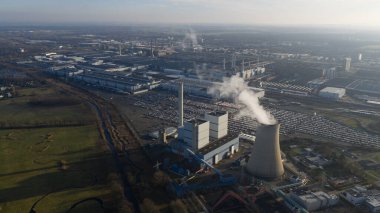 Almanya 'nın Wolfsburg kentindeki büyük otomobil üretim tesisinin hava aracı görüntüsü, otomotiv üretim tesisleri ve sanayi operasyonlarını destekleyen bir tesis içeriyor..