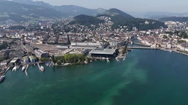 Lucerne, İsviçre 'nin yaz mevsiminde şehir merkezi, tren istasyonu, tarihi köprüler ve Lucerne Gölü' nün yer aldığı hava aracı manzarası, resimli göl manzaralı dağların arasında geçmektedir..