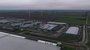 Middenmeer 'deki büyük bir veri merkezinin havadan yakın görüntüsü, bulut hizmetlerini, kolokasyon tesislerini ve küresel dijital talebi destekleyen yapay zeka altyapısını vurguluyor..