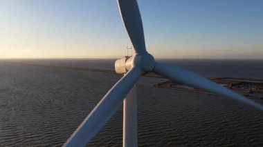 Hollanda 'daki Afsluitdijk' te, deniz aşırı rüzgar türbinlerinin yakın çekim videosu yenilenebilir enerji üretimi ve denizdeki sürdürülebilir enerji altyapısını gösteriyor..