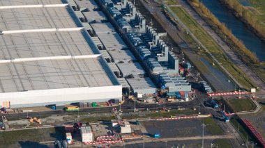 Eemshaven 'da inşaat halindeki büyük bir veri merkezi kompleksinin hava aracı görüntüsü, büyük ölçekli dijital altyapı, hiperölçekli kalkınma ve Kuzey Hollanda' nın sanayi limanı manzarasını vurguluyor..