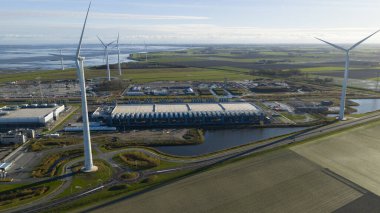 Eemshaven 'da inşaat halindeki büyük bir veri merkezi kompleksinin hava aracı görüntüsü, büyük ölçekli dijital altyapı, hiperölçekli kalkınma ve Kuzey Hollanda' nın sanayi limanı manzarasını vurguluyor..