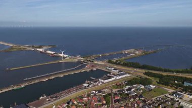 Geniş hava manzarası, kornwerderzand kilidi kompleksini yavaş yavaş afsluitdijk geçidinde, el değmemiş denizden Ijsselmeer ayırarak, ufukta uzak bir rüzgar çiftliği ile ortaya çıkarıyor.