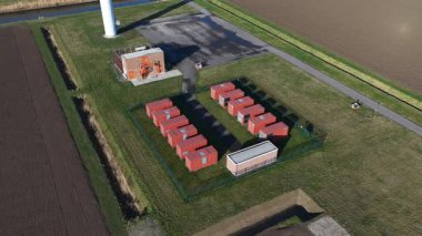 Hollanda 'da Middelharnis yakınlarında büyük batarya enerji depolama sistemlerine sahip modern bir rüzgar parkının insansız hava aracı videosu yenilenebilir enerji üretimi, şebeke dengelemesi ve ağ tıkanıklığının çözümlerini gösteriyor..