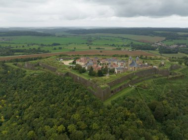 Montmedy Kalesi, tarihi taş duvarları, geleneksel köy ve kilisesi olan, dramatik bulutlu gökyüzünün altında yeşil ormanlara ve tarım arazilerine bakan bir tepeye tünemişti.