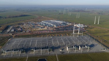 Eemhaven veri merkezi kompleksi ve onun karmaşık güç alt istasyonu, uzak yeşil alanlarda duran çok sayıda rüzgar türbini temeli sürdürülebilir enerji entegrasyonunu sembolize ediyor.