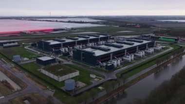 Hollands Kroon 'daki yüksek ölçekli veri merkezlerinin hava aracı videosu, modern dijital ekonomileri şekillendiren büyük ölçekli bilgisayar, bulut altyapısı, dijital depolama ve enerji yoğunluklu tesisleri gösteriyor..