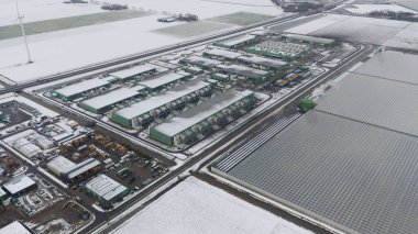 Kar tarlalarındaki modern seraların yanında büyük veri merkezleri ve soğutma üniteleri olan sanayi bölgesi, kış teknolojisi altyapısı ve sürdürülebilir tarım entegrasyonunu gösteriyor