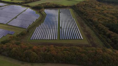 Fotovoltaik panelleri olan ve sonbahar ormanları ve yeşil alanları olan kırsal bir alana yerleşen güneş panelleri güneş ışığından temiz ve yenilenebilir elektrik üretiyor.