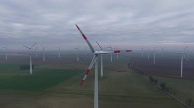 Bulutlu bir günde Almanya 'nın kırsal kesimindeki bir rüzgar türbininin insansız hava aracı görüntüleri yenilenebilir enerji üretimini ve sürdürülebilir elektrik geçişini gösteriyor..