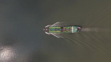 Sakin bir nehirde seyreden büyük bir endüstriyel petrol tankerinin, deniz ticareti, lojistik ve yakıt taşımacılığını ön plana çıkaran sersemletici hava manzarası.