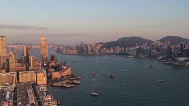 Hong Kong, Hong Kong Özel İdari Bölgesi, Çin, 13 Şubat 2026: Hong Kong 'un hareketli sularında çok sayıda tekne ve feribot dolaşırken, batan güneşin sıcacık ışığıyla aydınlanan gökdelenlerle ikonik gökyüzü manzarası
