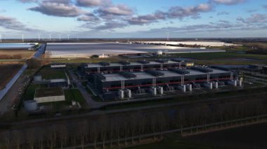 Hollands Kroon 'daki yüksek ölçekli veri merkezlerinin hava aracı videosu, modern dijital ekonomileri şekillendiren büyük ölçekli bilgisayar, bulut altyapısı, dijital depolama ve enerji yoğunluklu tesisleri gösteriyor..
