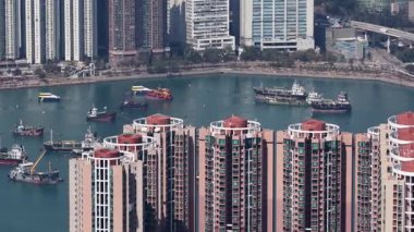 Yükselen gökdelenler ve yoğun apartmanlar kalabalık rıhtım boyunca çarpıcı bir şehir manzarası yaratıyor. Hong Kong 'daki yoğun körfezde çok sayıda sanayi gemisi ve gemi dolaşıyor.