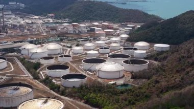 Ham petrol ve petrol ürünleri için sayısız beyaz depolama tanklarının yer aldığı büyük bir petrol rafineri kompleksinin geniş hava manzarası, sahil yakınlarındaki bir sanayi bölgesinde yer almaktadır.