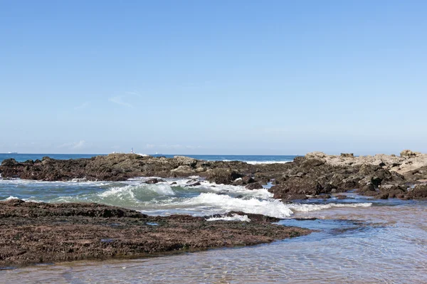 海の波が海岸に岩や砂の上に来る — ストック写真