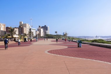 Yayalar ve bisikletliler Durban'ın döşeli Beach Promenade üzerinde