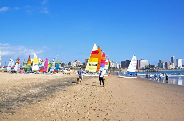 Muchas personas y coloridos barcos de vela en la playa —  Fotos de Stock