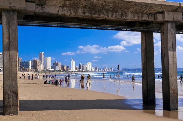 Kijk onder pier op de skyline van de stad en strand — Stockfoto