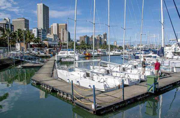 Wooden walkway and yachts against city skyline — Stock Photo, Image
