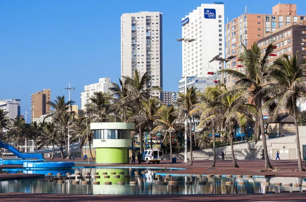 Area piscina contro palme e città Skyline — Foto Stock