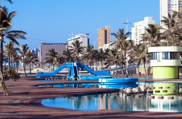 Mavi yüzme eğlence havuzu ve palmiye ağaçları — Stok fotoğraf