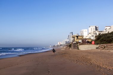 Umhlanga Rocks erken sabah plajda bir sörfçü