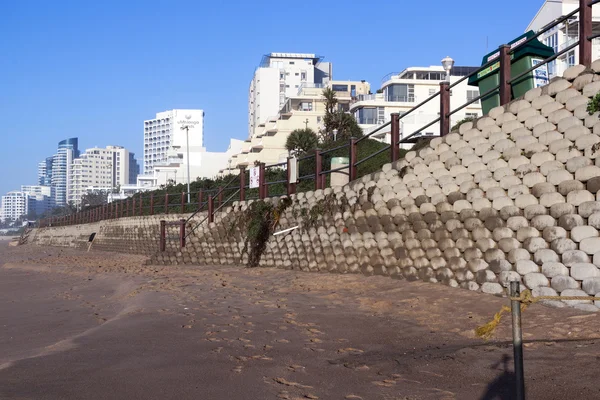 针对城市天际线的空海滩上的混凝土挡墙。 — 图库照片