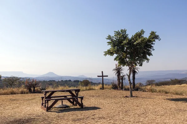 Trä picknickbord och platser på kulle i torrt landskap — Stockfoto