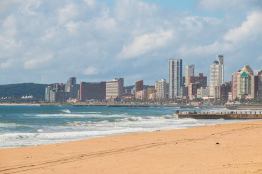 Sahilde rıhtım ve yüksek binalar ve arka planda blöf