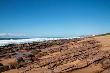 Kıyı şeridindeki katmanlı kayalar alçak gelgitte
